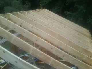 New roof rafters set over an addition before sheathing in Daykin