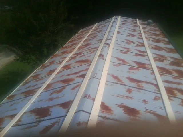 Rusted metal roof panels with new wood purlins before replacement — Storm Damage Roof Repair in Daykin by Roofing Brothers