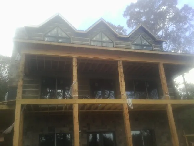 Dormers and porch framing on a large log home under construction — Roof Coating work by our crew in Daykin