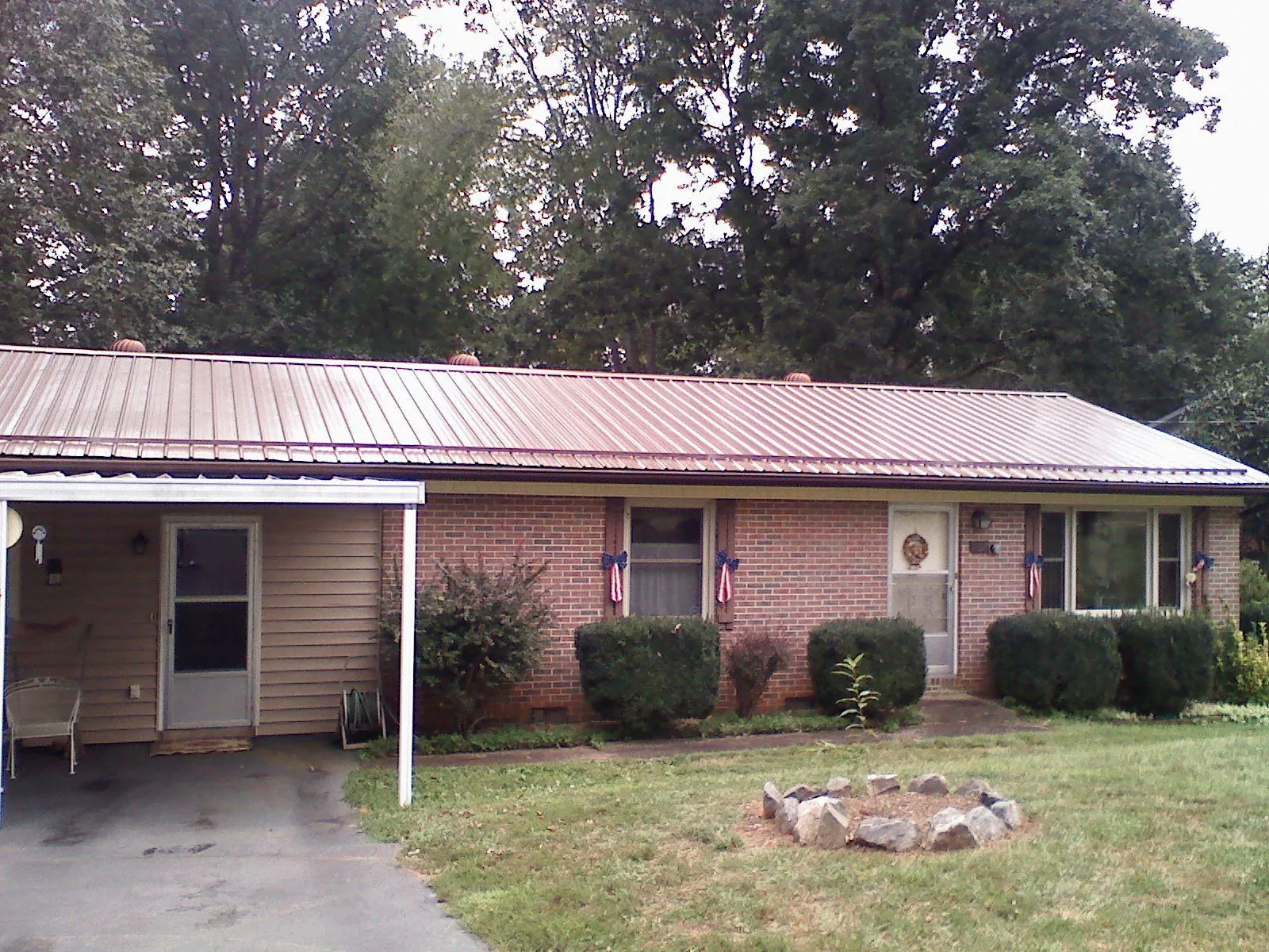 Bronze metal roof and carport on a brick ranch home — Roof Repair work by our crew in Daykin