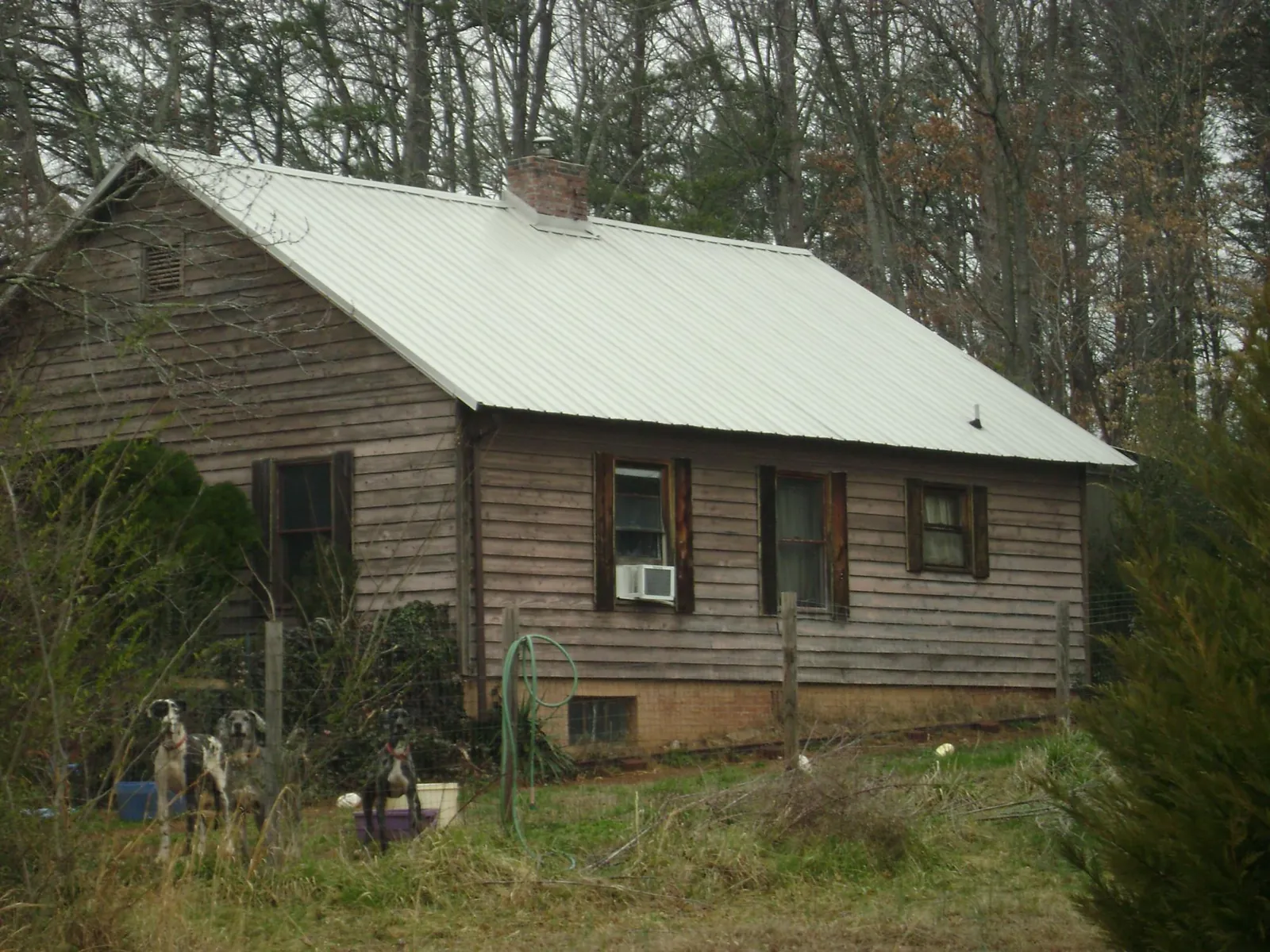 White metal roof on an old wood sided farmhouse, from a Metal Roof Installation job in Daykin